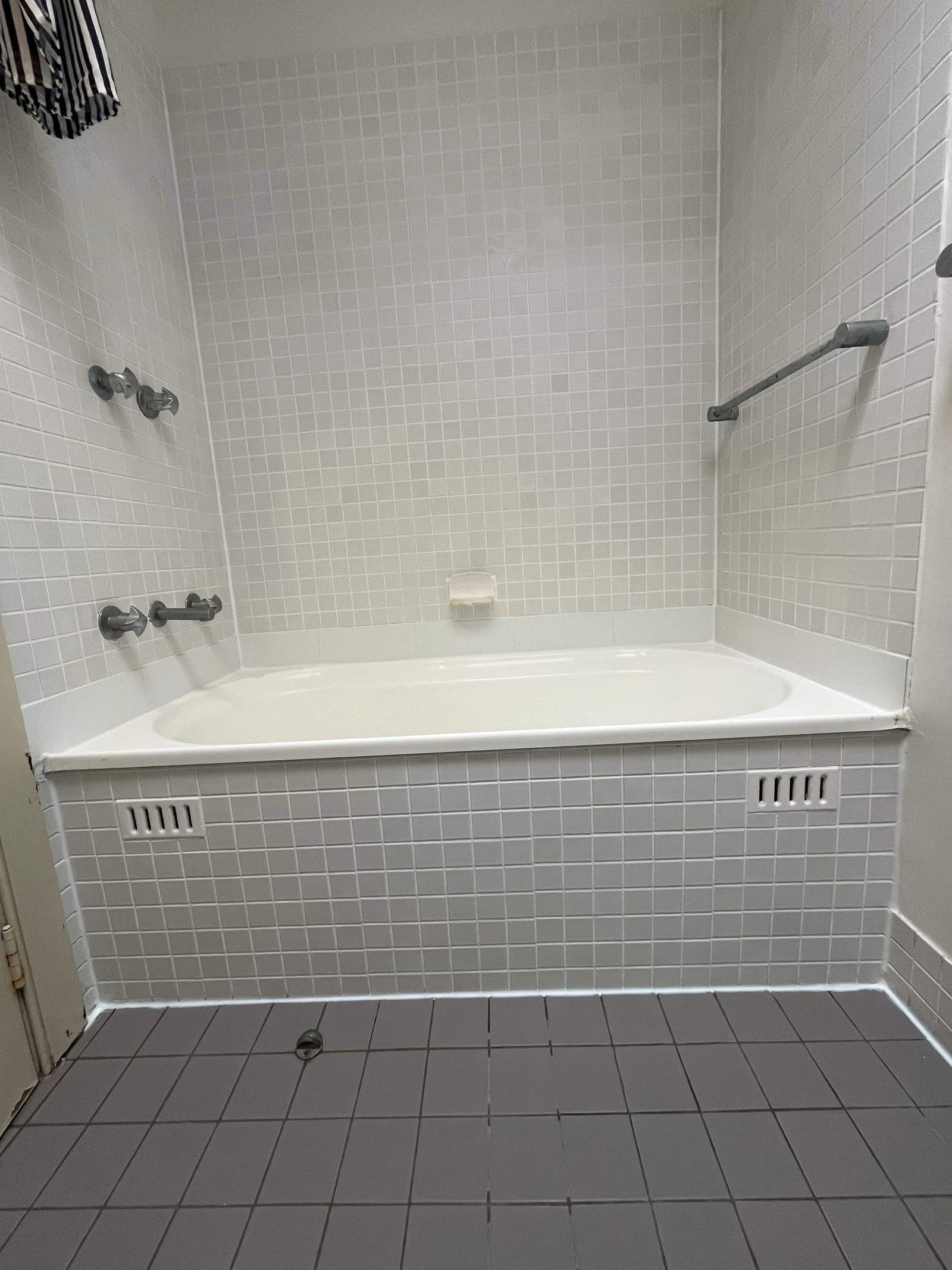 Sealed bath surround with white mosaic wall tiles