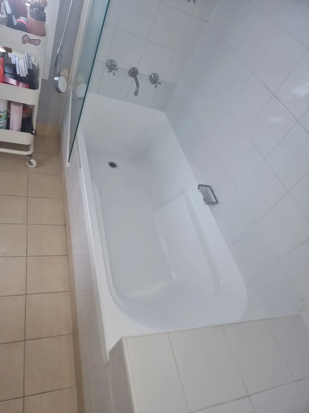 Sealed white-tiled bath surround