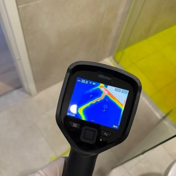 Thermal imaging camera tracing a leak path across a dye-tested shower floor