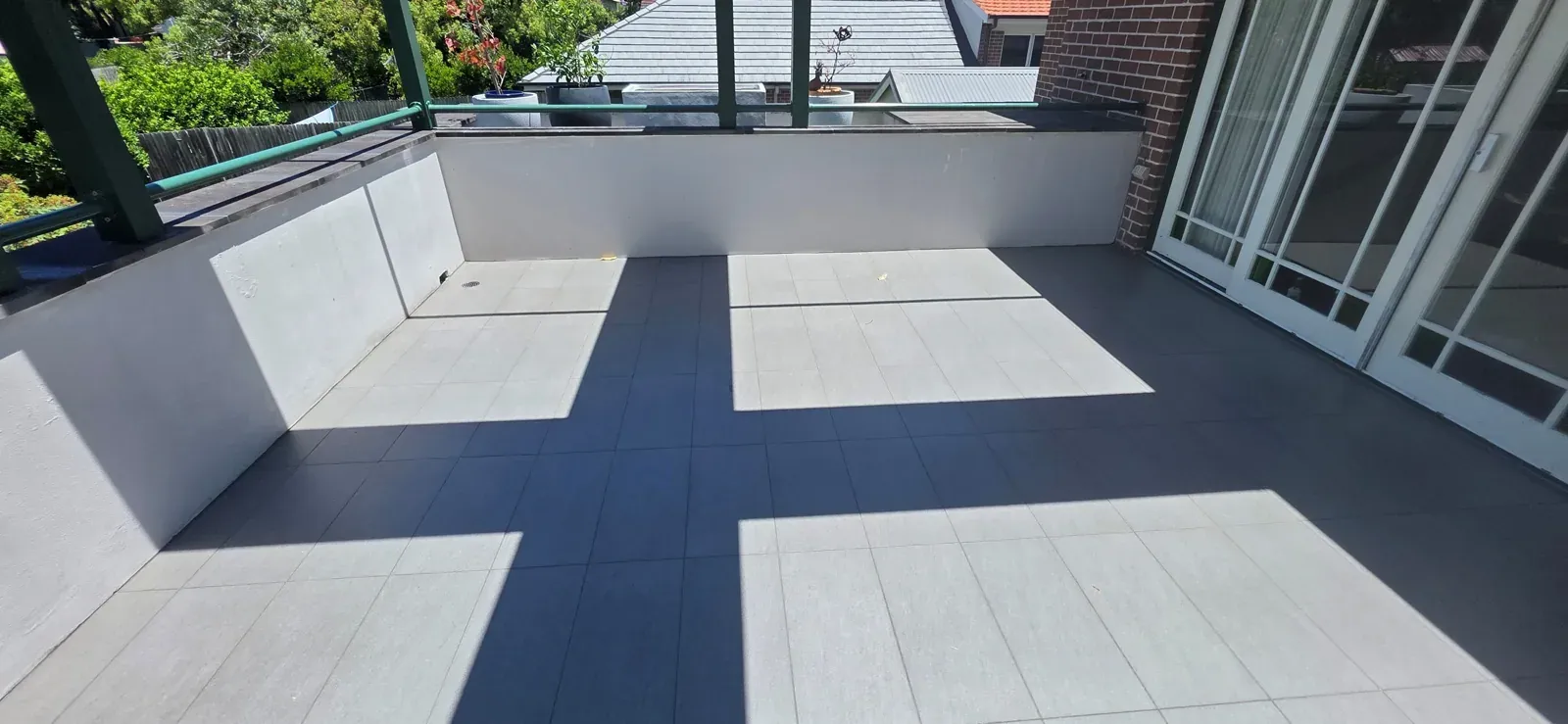 Sealed rooftop terrace in grey tiles with a glass balustrade