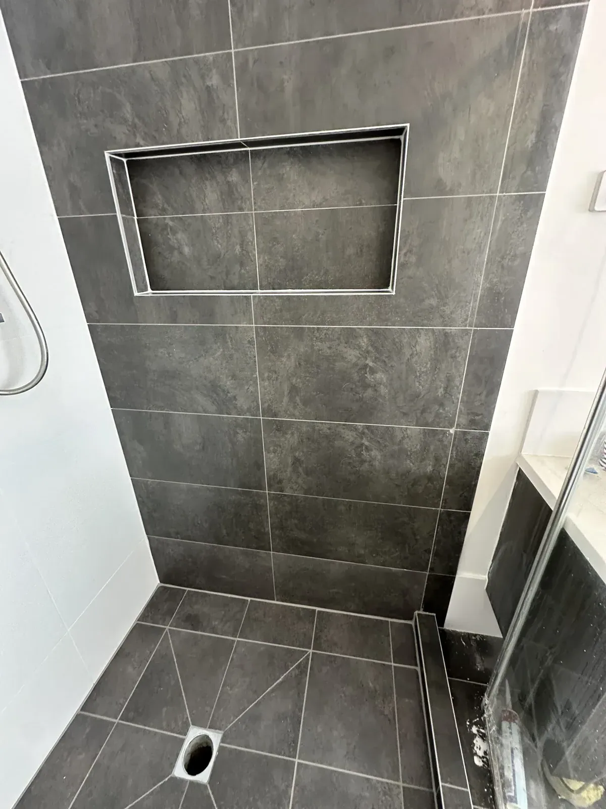 Sealed shower in charcoal tiles with a tiled niche